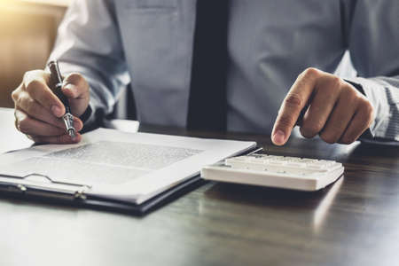 Businessman or lawyer accountant working financial investment on office, using calculator analysis finance document report real estate and home loan insurance.の写真素材