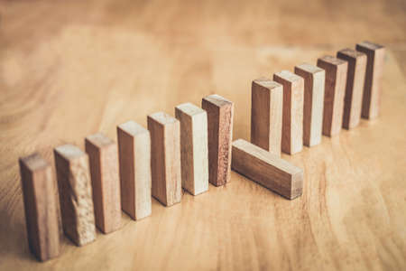 Wooden block on a line of domino, Risk and strategy in business.の写真素材