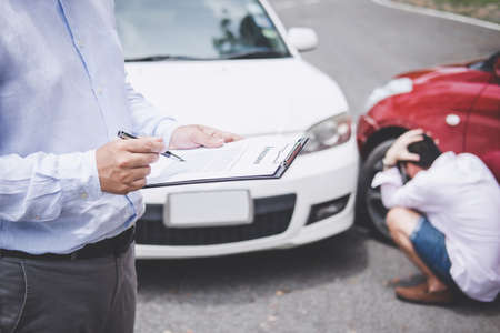 Traffic Accident and insurance concept, Insurance agent working on report form with car accident claim process.の写真素材