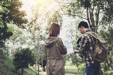 Two Young Traveler with backpack, are holding map relaxing in greens jungle and enjoying with...