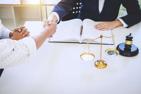 Handshake after good cooperation greeting, Having meeting with team at law firm, Consultation between a female lawyer and businessman customer, tax and the company of real estate concept.の写真素材