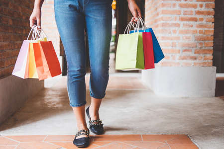 Fashion shopping girl, Young woman carrying colorful shopping bags while walking along the shopping mall.の写真素材