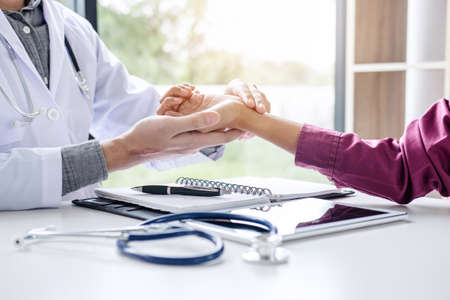Medicine and health care concept, Doctor in white coat taking and checking the Patient's wrist pain during the examination.の写真素材
