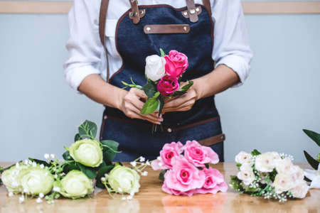 Arranging artificial flowers vest decoration at home, Young woman florist work making organizing diy artificial flower, craft and hand made concept.の写真素材