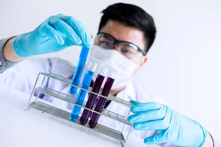 Biochemistry laboratory research, Scientist or medical in lab coat holding test tube with reagent...