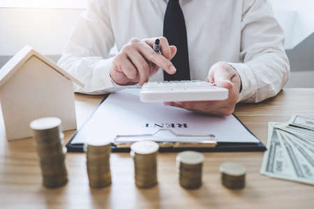 Businessman working doing finances and calculation cost of real estate investment while be signing to contract, Concept mortgage loan approval.の写真素材