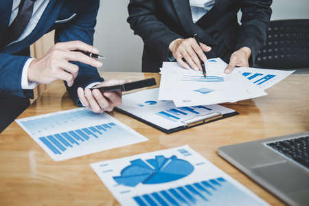 Executive team discussing the charts and graphs working in business strategy and financial plan to...