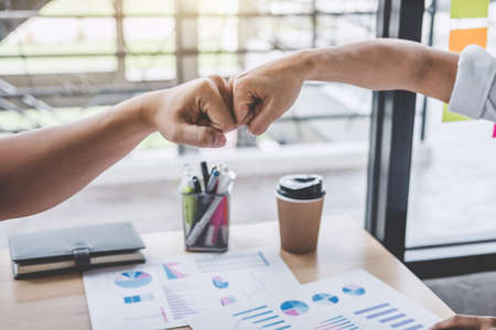 Teamwork of businessman partnership giving fist bump to greeting start up contract for both companies business strategy project.の写真素材
