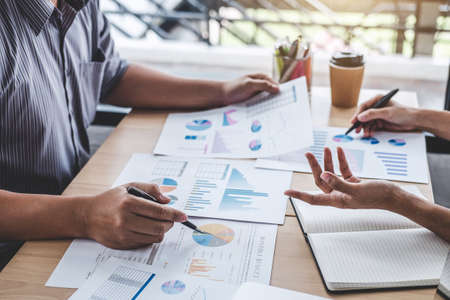 Business team colleagues discussing working analysis with financial data and marketing growth report...