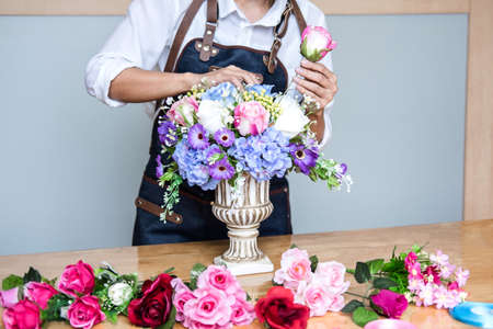 Arranging artificial flowers vest decoration at home, Young woman florist work making organizing diy...