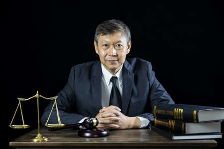 Counselor or Male lawyer working on courtroom sitting at the table. Legal law, Judge gavel with Justice lawyers advice with gavel and Scales of justice.の写真素材