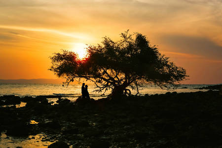 Silhouette of happy couple in love on the beach, Lovers having moments summer vacation for honeymoon.の写真素材