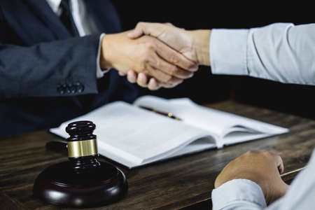 Congratulation and collaboration concept, Shaking hands after good cooperation, Businessman handshake with male lawyer after discussing good deal of contract in courtroom.の写真素材