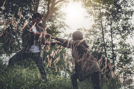 Helping hand hiking get help friend from man in a dangerous situation to hike in the mountains.の写真素材