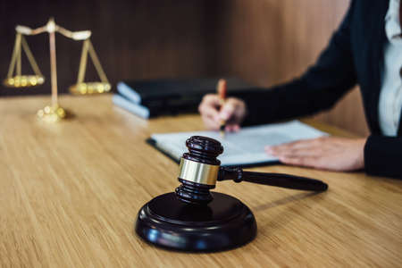 Judge gavel with Justice lawyers, Businesswoman in suit or lawyer working on a documents. Legal law, advice and justice concept.の写真素材
