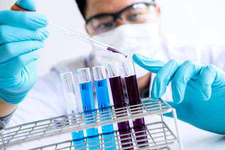 Biochemistry laboratory research, Chemist is analyzing sample in laboratory with equipment and...