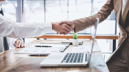 Business team two executive shaking hands after a meeting and conference to sign agreement and become partner in the office, results of their successful teamwork, contract between their firms.の写真素材