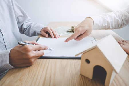 Business Signing and analyzing a contract buy - sell house, insurance agent analyzing cost about home investment loan Real Estate, Concept mortgage loan approval.の写真素材