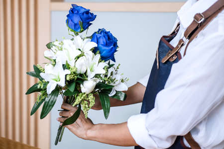 Arranging artificial flowers vest decoration at home, Young woman florist work making organizing diy artificial flower, craft and hand made concept.の写真素材