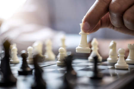 Businessman's hand playing chess game to development analysis new strategy plan, business strategy leader and teamwork concept for win and success.の写真素材