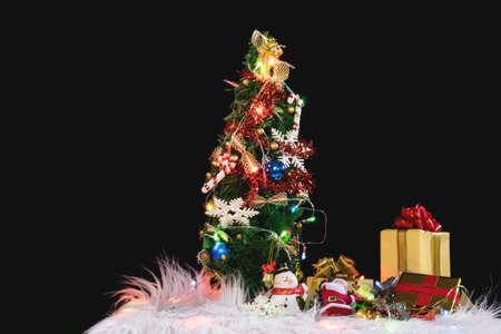 Christmas holiday background with decorated christmas tree, santa claus and gift boxes on black...