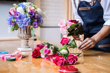 Arranging artificial flowers vest decoration at home, Young woman florist work making organizing diy...