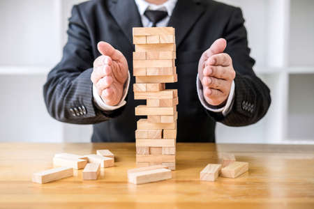 Alternative risk concept, plan and strategy in business protect with balance wooden stack with hand...