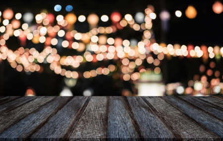 Selective Empty wooden table in front of abstract blurred festive light background with light spots...