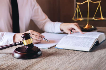 Judge gavel with scales of justice, male lawyers working having at law firm in office. Concepts of law advice and justice.の写真素材