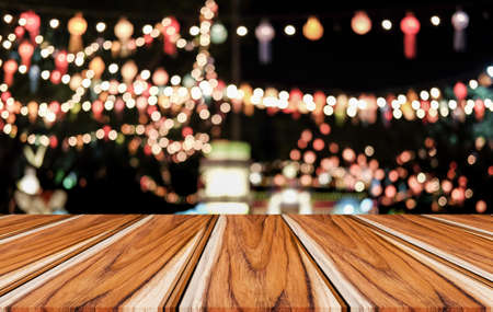 Selective Empty wooden table in front of abstract blurred festive light background with light spots and bokeh for product montage display of product.の写真素材