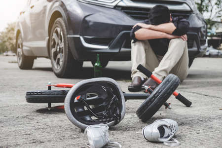 Image of shocked and scared driver after accident involved Kid's bike and helmet lying on the road on pedestrian crossing after accident collision with drunk car driver.の写真素材