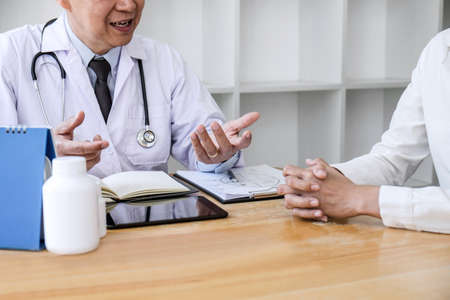 Professor Doctor consulting with patient discussing something and recommend treatment methods, Presenting results on report, Medicine and health care concept.の写真素材