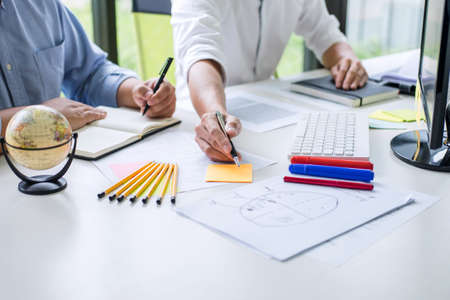 Tutor books with friends, Man sitting pointing studying together at desk with classmates exams,...