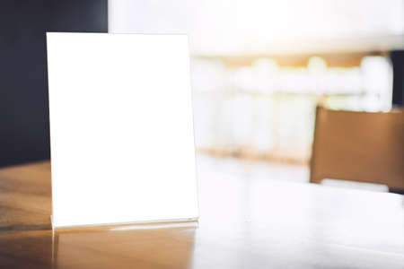 Mock up blank menu frame on table in coffee shop stand for your text of display your product.