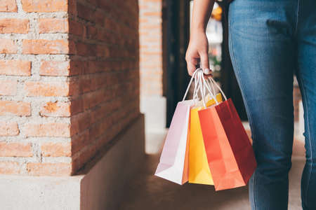 Fashion shopping girl, Young woman carrying colorful shopping bags while walking along the shopping mall.の写真素材