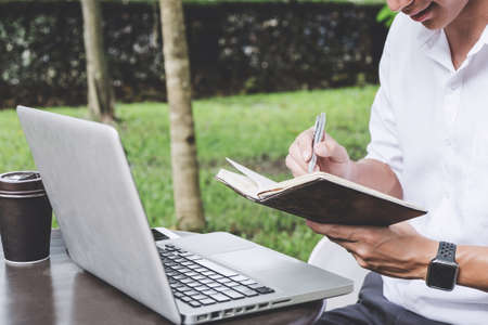 Image of businessman working with laptop and analysis financial document data on table in outdoor office, finance,investment, business concept and Accounting,Economic,commercial.の写真素材