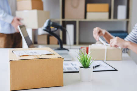 Shipment Online Sales, Small business or SME entrepreneur owner delivery service and working packing box, business owner working checking order to confirm before sending customer in post office.の写真素材