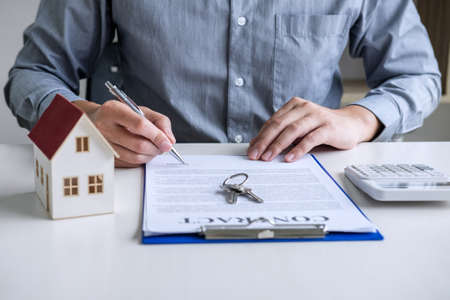 Businessman working doing finances and calculation cost of real estate investment while be signing to contract, Concept mortgage loan approval.の写真素材