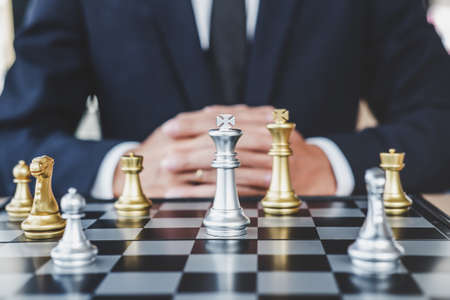 Businessman playing chess game reaching to plan strategy for success, thinking for planning overcoming difficulty and achieving goals business strategy for win, management or leadership concept.の写真素材