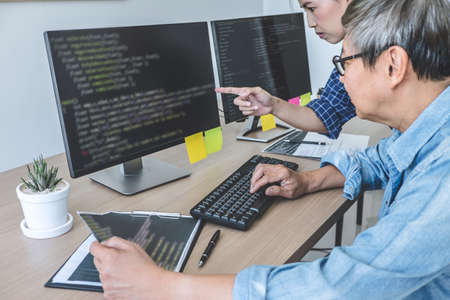 Two professional programmers cooperating at Developing programming and website working in a software...