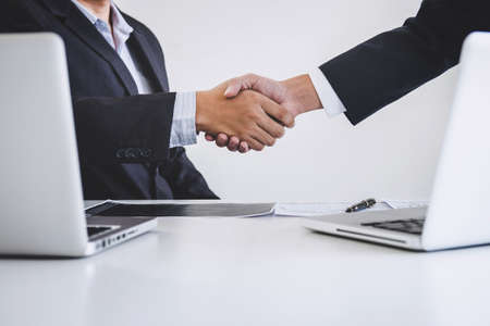 Business handshake after discussing and analysis graph stock market trading good deal of Trading to...