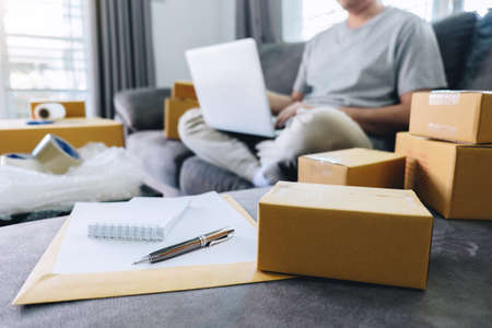 Small business parcel for shipment to client, Young man received online shopping parcel opening boxes and buying items by credit card, online marketing on purchase order package product.の写真素材