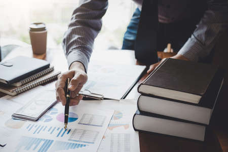 Businessman pointing at graph and chart to analysis use for plans to improve quality, business...