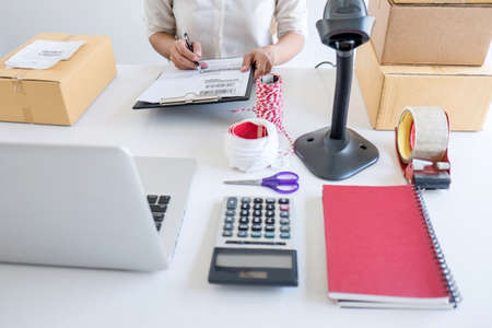Young entrepreneur SME receive order client and working with packaging sort box delivery online...