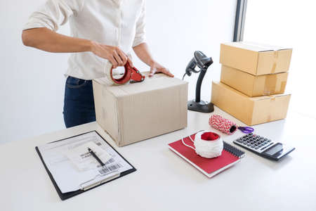 Small business owner delivery service and working packing box, business owner working checking order to confirm before sending customer in post office, Shipment Online Sales.の写真素材