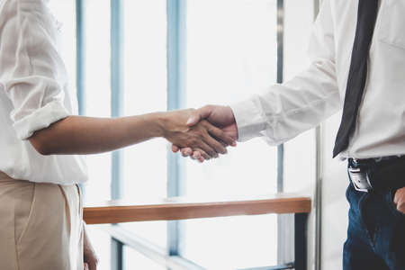 Business team two executive shaking hands after a meeting and conference to sign agreement and become partner in the office, results of their successful teamwork, contract between their firms.の写真素材