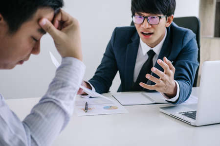 Boss and executive team feeling stress and serious of fail business, Team dispute of failure holding heads in hands with problems with a pile of work, sadness by bad news.の写真素材