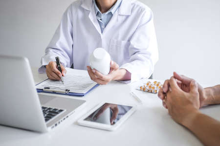 Doctor consulting patient discussing something symptom of disease and recommend treatment methods, presenting results on report and prescription, Medicine and health care concept.の写真素材