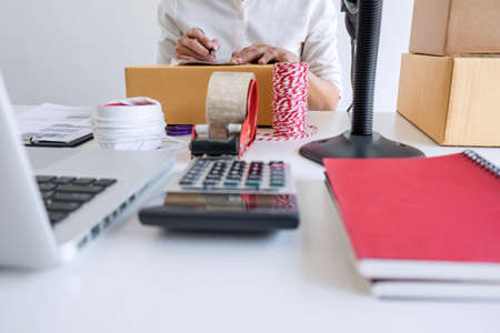 Shipment Online Sales, Small business or SME entrepreneur owner delivery service and working packing box, business owner working checking order to confirm before sending customer in post office.の写真素材