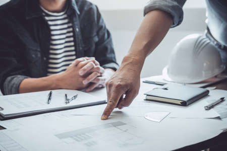 Construction and structure concept of Engineer or architect meeting for project working with partner and engineering tools on model building and blueprint in working site, contract for both companies.の写真素材